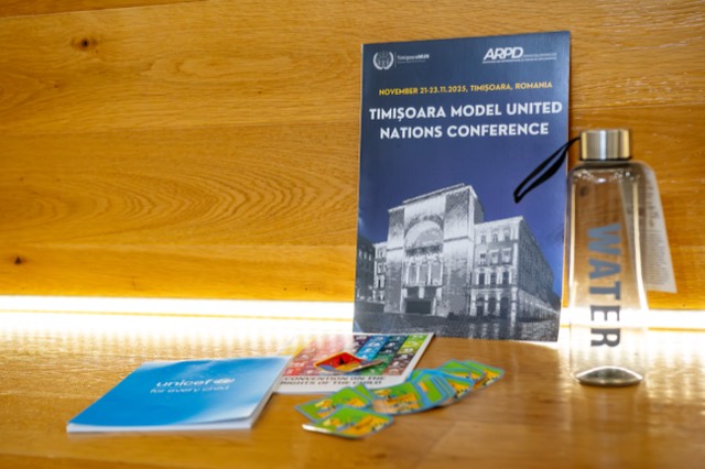 Timisoara Model United Nations program booklet displayed with a water bottle and UNICEF materials.